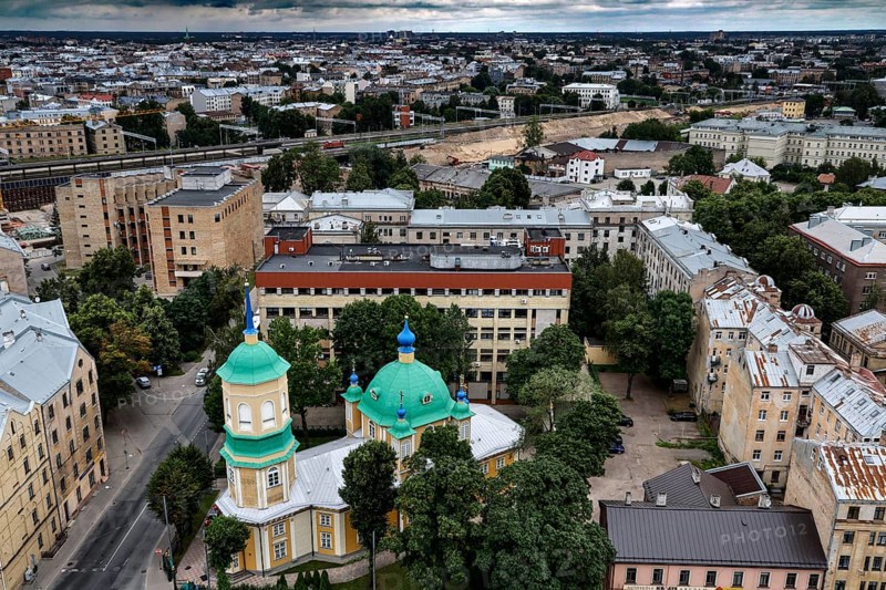 Annunciation of Our Lady in the midst of municipal buildings and green tree roofs, Riga, Latvia