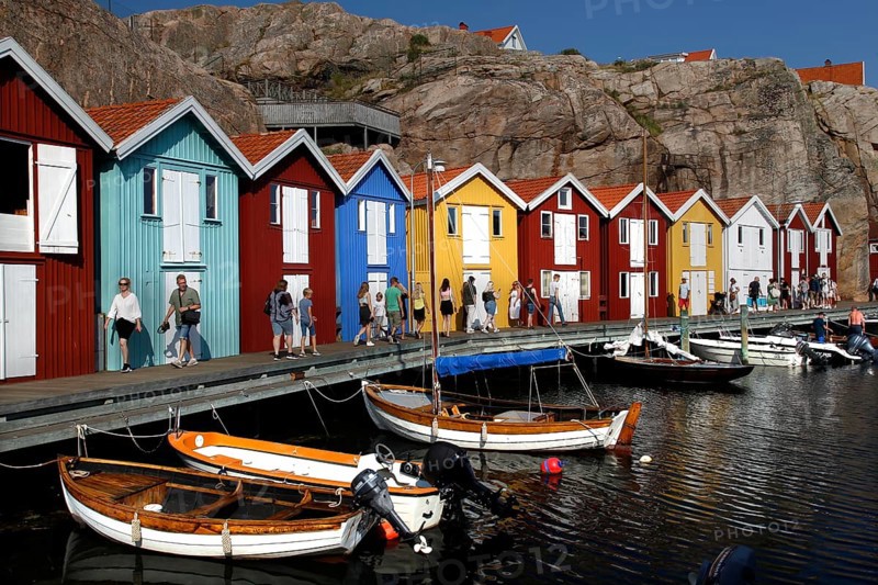 Lively harbor with colorful boathouses and boats situated on the waterfront, Smögen, Västra Götaland, Sweden