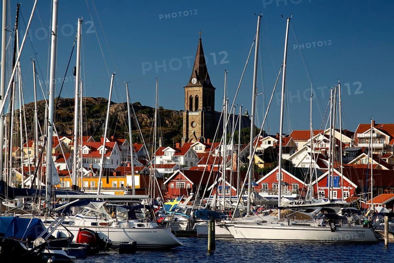Bustling port of Fjällbacka with sailboats and a church in the background, Fjällbacka, Sweden