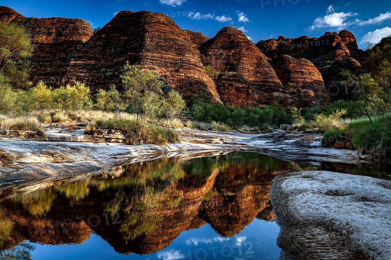 Dramatic rocky landscape reflected in the clear water of a waterhole, Purnululu National Park, Western Australia, Australia