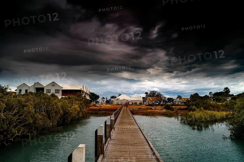 Streeters Jetty in Broome with dramatic clouds over coastal landscape, Broome, Western Australia, Australia