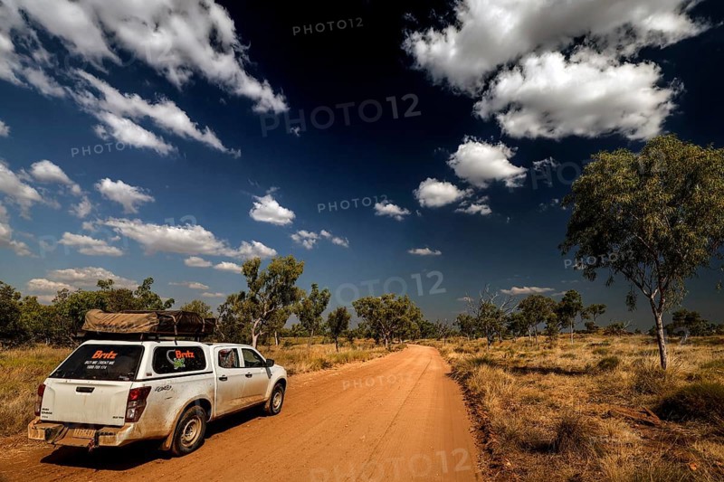SUV on dusty road under dramatic sky in Purnululu National Park, Purnululu National Park, Western Australia, Australia