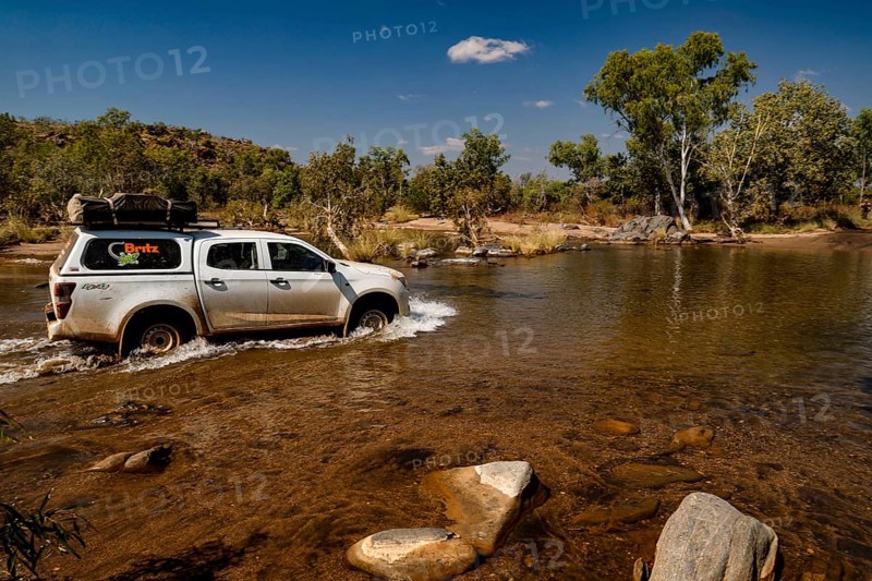 Vehicle crosses shallow river in remote area of Purnululu National Park, Purnululu National Park, Western Australia, Australia