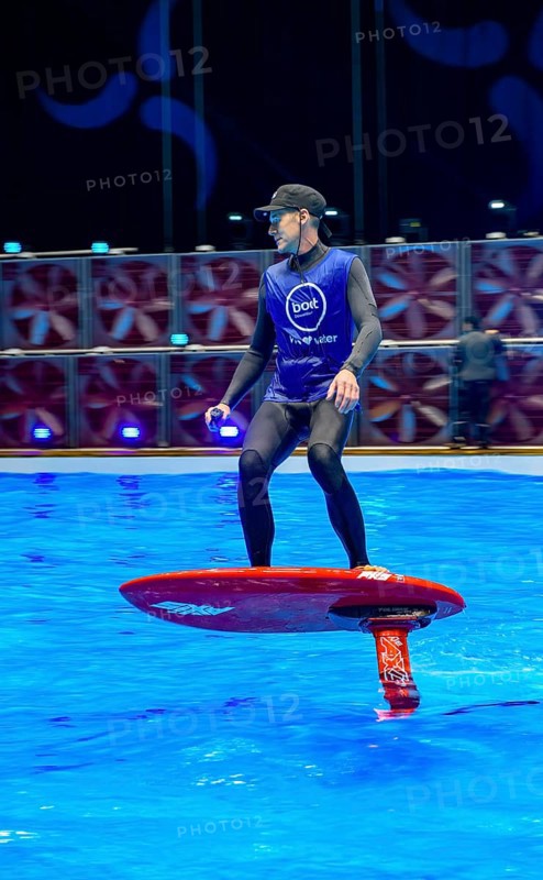 Press photo dynamic photo of eFoil surfer in the large XXL pool in Hall 17 of Messe Boot Düsseldorf, in the background the motto of Messe boot We Love Water, Messe Boot, Düsseldorf, North Rhine-Westphalia, Germany