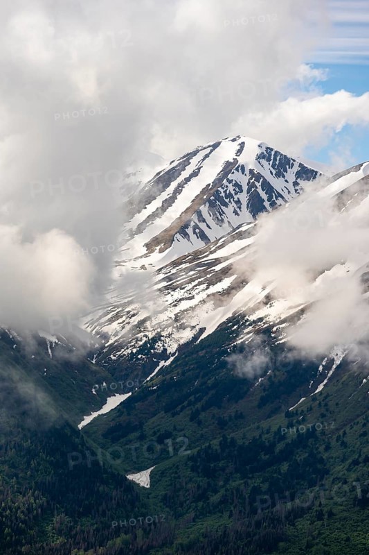 Fog sweeps around mountain peaks with remnants of snow, view from Slaughter Ridge Trail, Cooper Landing, Kenai Peninsula, Alaska, USA