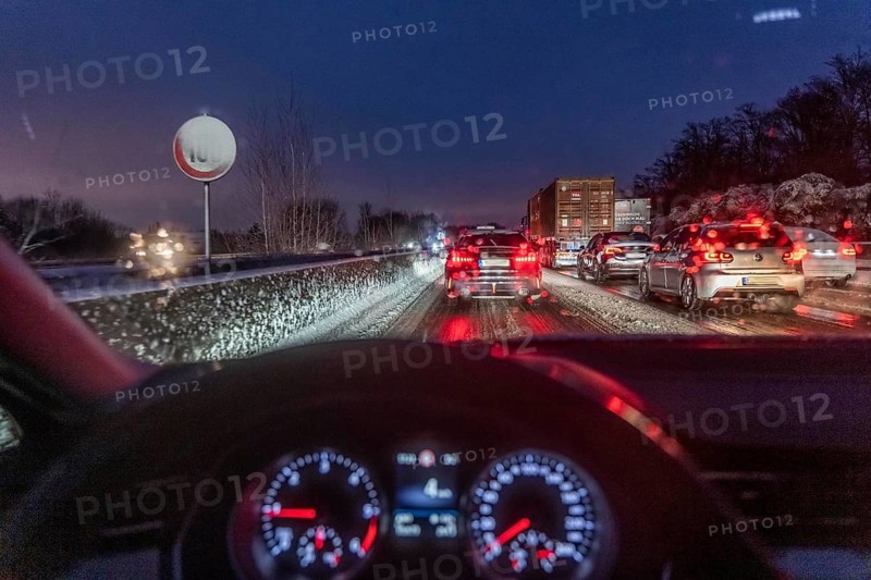 Driving in winter, in snow, motorway, rear lights, brake lights, speedometer, cockpit