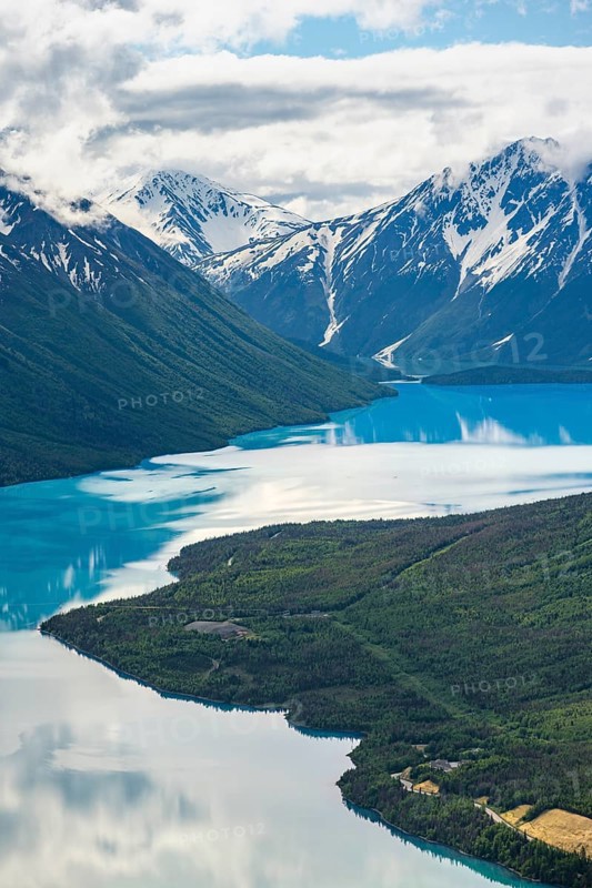 View of snowy mountains in spring and turquoise Kenai Lake with reflection, Slaughter Ridge Trail, Cooper Landing, Kenai Peninsula, Alaska, USA