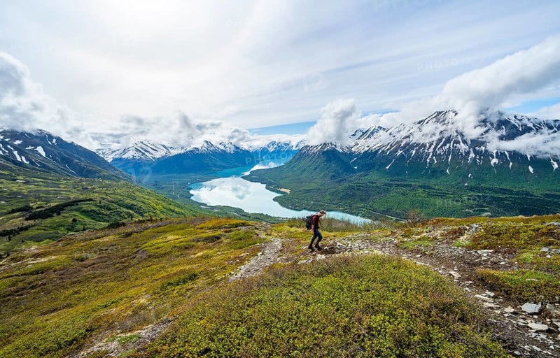 Climbers on a hiking trail, Slaughter Ridge Trail, view of snowy mountains and turquoise lake Kenai Lake, Cooper Landing, Kenai Peninsula, Alaska, USA