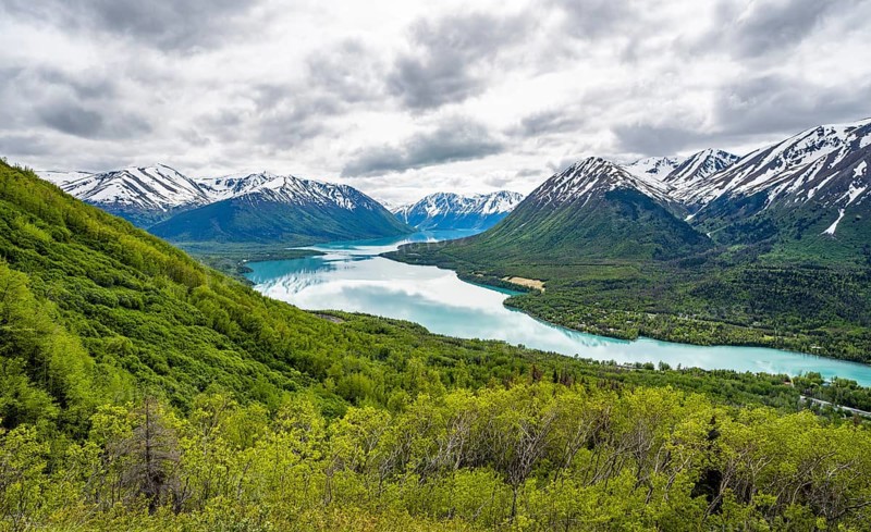 View of snowy mountains in spring and turquoise blue Kenai Lake, Slaughter Ridge Trail, Cooper Landing, Kenai Peninsula, Alaska, USA