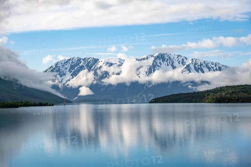 Snowy mountains in spring are reflected in turquoise blue Kenai Lake, Cooper Landing, Kenai Peninsula, Alaska, USA