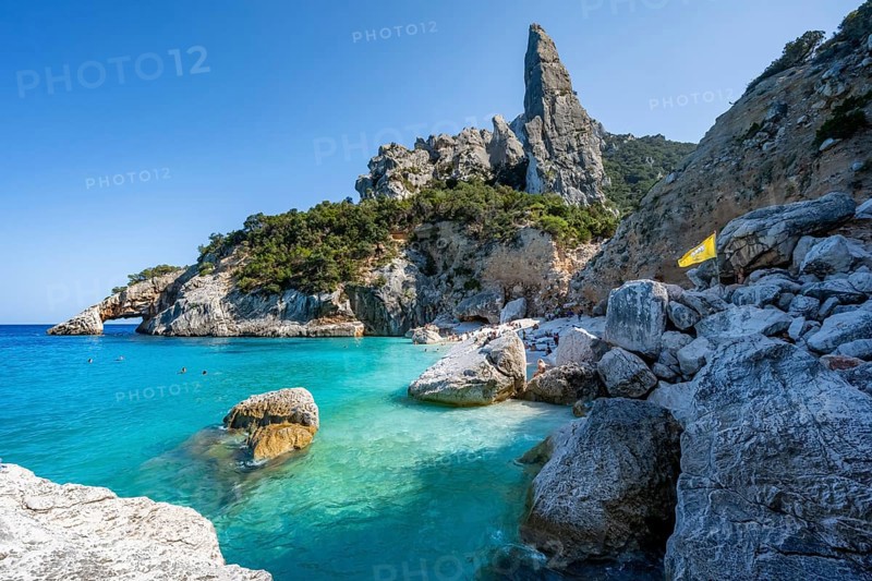 Light blue clear sea on a dream beach on Cala Goloritzé, picturesque rocky coast, steep coast with rock pin L'Aguglia, Golfo di Orosei, Baunei, Sardinia, Italy