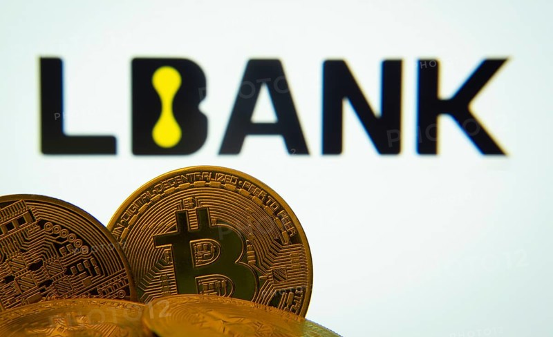 Dhaka, Bangladesh- 03 Sep 2025: Close-up of Bitcoin coins with the LBank logo visible on a screen in the background