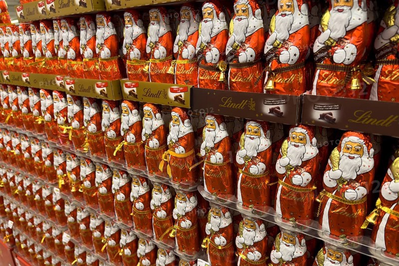 Display on the shelf of chocolate Santa Claus chocolate Santa Claus Santa Claus Santa Claus Santa Claus chocolate Santa Claus chocolate Santa Claus chocolate lice Santa Claus chocolate lice Santa Claus in color red of red staniol paper made of chocolate arranged like army of Santa Claus, Germany