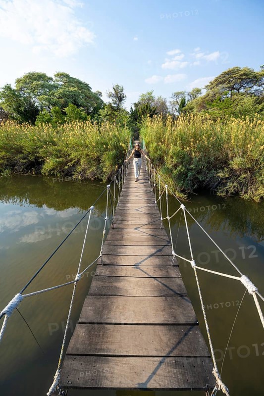 Toruist on the Kavango River, suspension bridge at Camp Kwando, Zambezi region, Caprivi Strip, Namibia