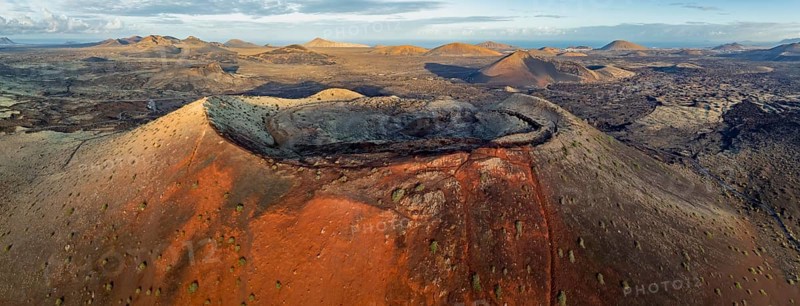Caldera Colorada volcano, picturesque volcanic landscape with volcanic craters and lava fields in morning light, Parque Natural de Los Volcanes, aerial view, Lanzarote, Canary Islands, Spain