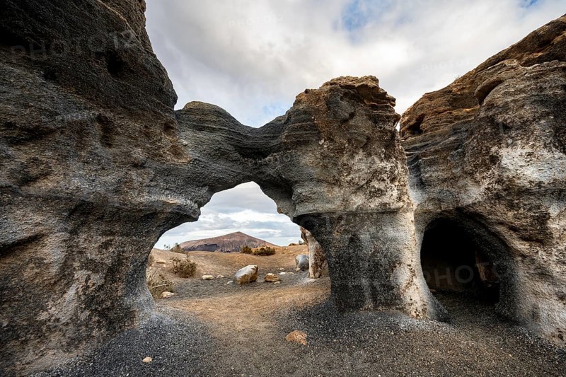 Eroded rock formations, volcanic landscape with dramatic cloudy skies, Ciudad Estratificada or Los Roferos, Antigua Rofera de Teseguite, Lanzarote, Canary Islands, Spain