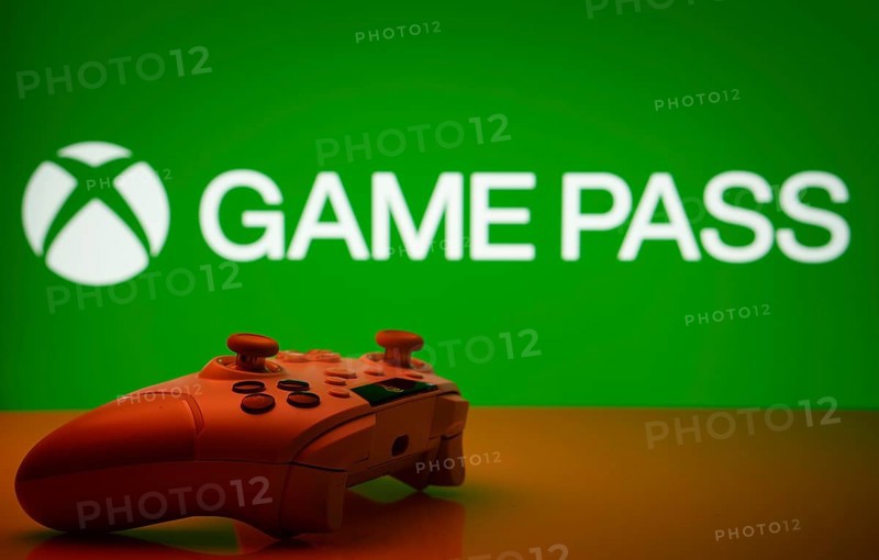 Dhaka, Bangladesh- 19 Sep 2025: A close-up of a white gamepad with the Xbox Game Pass seen on screen in the background