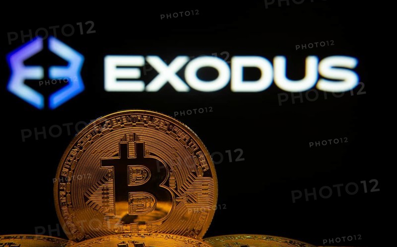 Dhaka, Bangladesh- 06 Sep 2025: Close-up of Bitcoin coins with the Exodus logo visible on a screen in the background