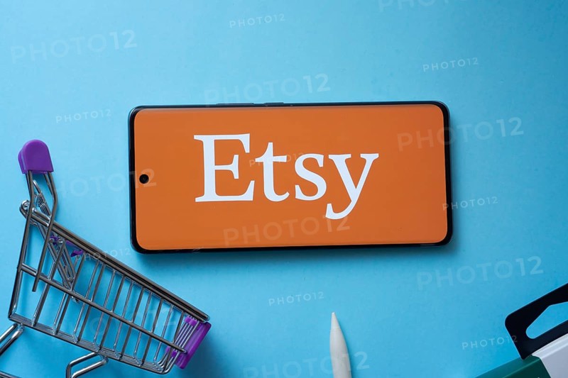 Dhaka, Bangladesh- 03 July 2025: Smartphone displaying Etsy logo with shopping cart on a blue background