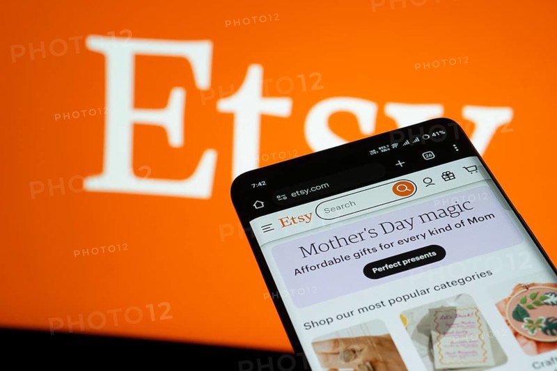 Dhaka, Bangladesh- 03 July 2025: Smartphone displaying Etsy web interface against Etsy logo background