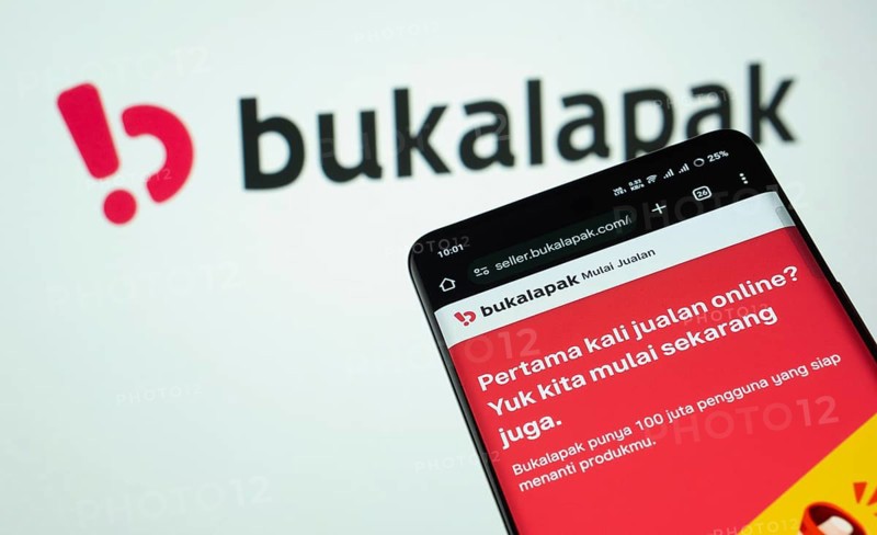 Dhaka, Bangladesh- 03 July 2025: Smartphone displaying Bukalapak web interface against Bukalapak logo background