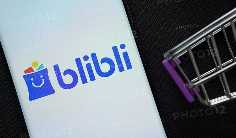 Dhaka, Bangladesh- 03 July 2025: A smartphone displaying the Blibli logo next to a miniature shopping cart on a background