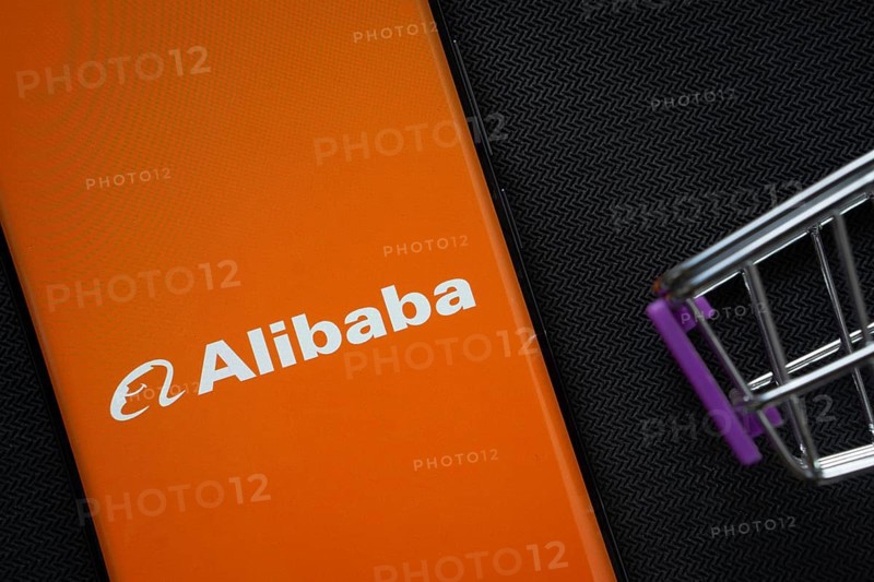Dhaka, Bangladesh- 03 July 2025: A smartphone displaying the Alibaba logo next to a miniature shopping cart on a background