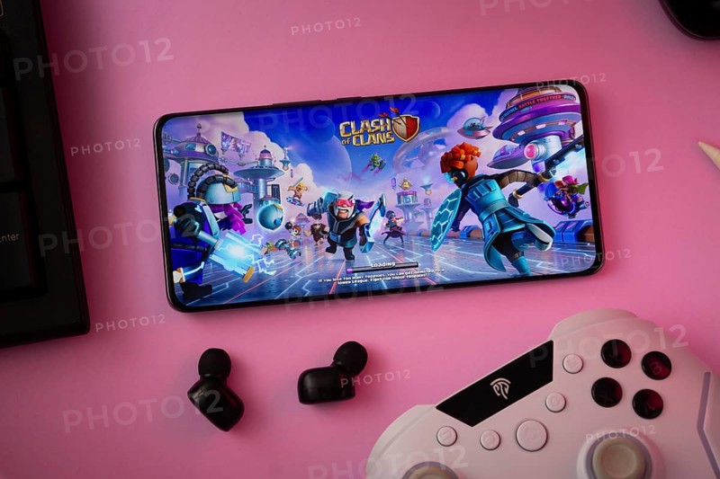 Dhaka, Bangladesh- 15 July 2025: A close-up of a gamepad with the Clash of clans seen on smartphone