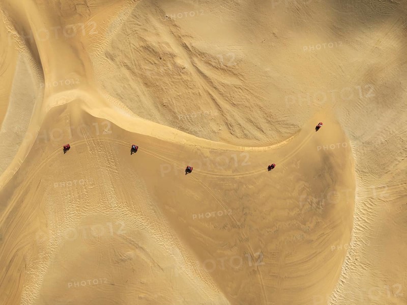 Quad bikes in the dunes of the Namib Desert in the vicinity of the coastal town of Swakopmund. Aerial view. Drone shot. Namibia