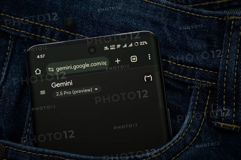 A smartphone displaying the Goolge Gemini web interface peeks out of a denim pocket