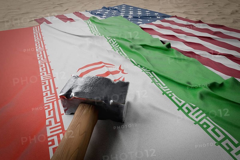 Large hammer, american and Iranian flags resting on desert sand