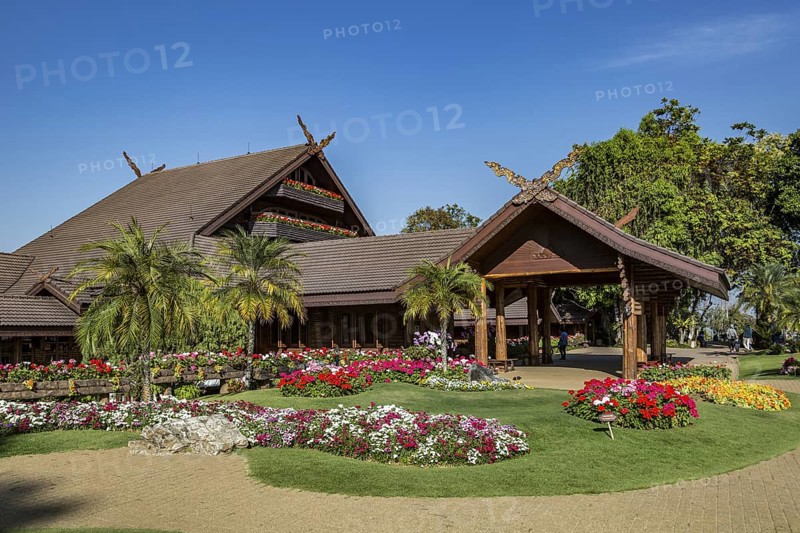 Ornate trees and lush flower gardens enhance the Lanna and Swiss architecture of the Doi Tung Royal Villa inside the Doi Tung tourist attraction in Chiang Rai, Thailand