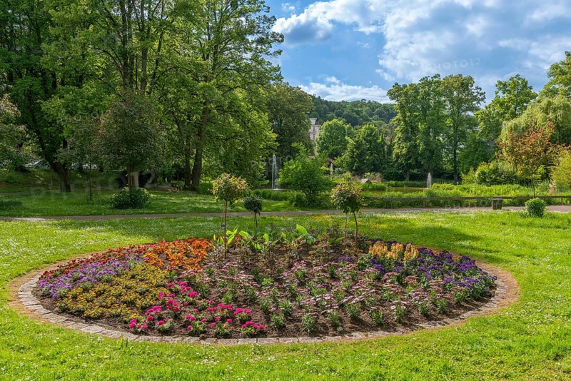 Park am Schwanen Teich, Bad Sooden, Allendorf, district Bad Sooden, round bed with blooming flowers, fountains, well-tended lawn, deciduous trees, blue sky, clouds, Werra-Meissner-Kreis, Hesse, Germany