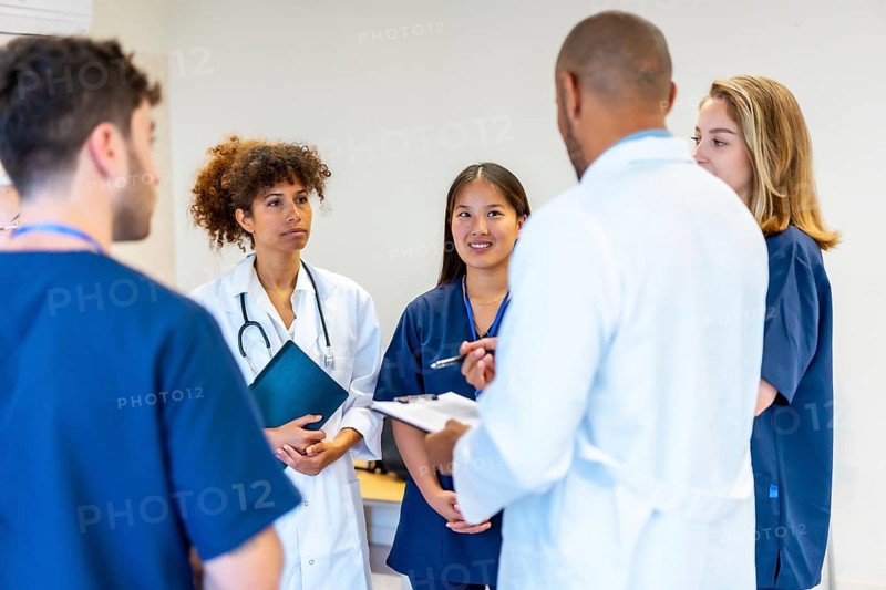 Diverse medical professionals collaborating, sharing expertise, and reviewing patient information during a productive meeting in a hospital setting