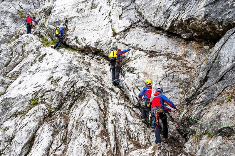 Mountain rescuers from Bergwacht Bayern climbing a steep rock face on Hoher Göll, Berchtesgaden, Berchtesgadener Land, Upper Bavaria, Bavaria, Germany
