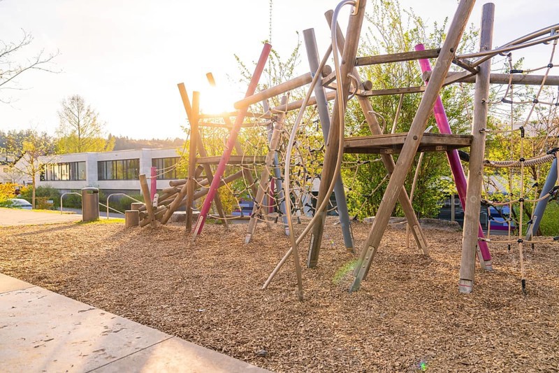 Sunlit playground with wooden climbing structures, Christiane Herzog Realschule, Nagold, district of Calw, Germany