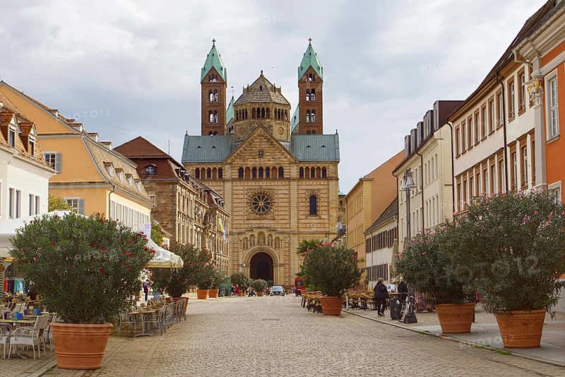 Historic architecture along a cobbled street, Speyer Cathedral in the background under clouds, Speyer