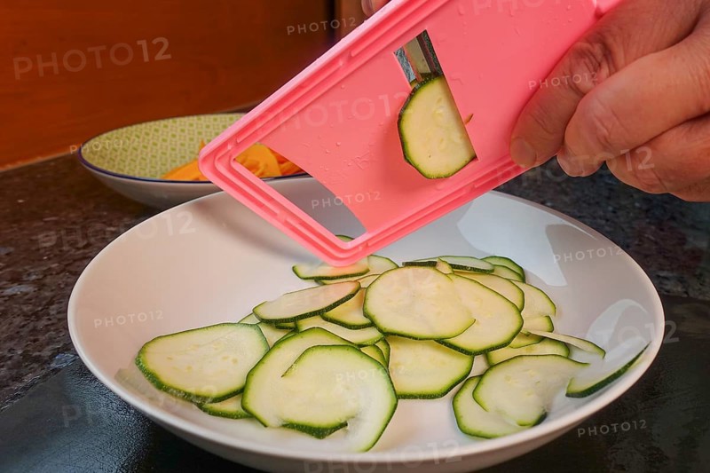 Swabian cuisine, preparing courgettes for mini dinettes, slicing vegetables, vegetable slicer, healthy, vegetarian, typical Swabian reinterpreted, man's hand, plate, traditional cuisine, food photography, studio, Germany