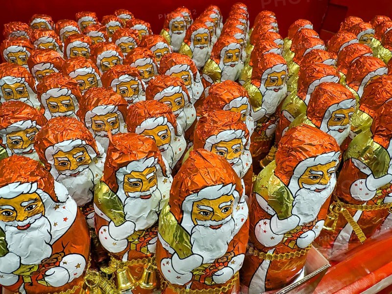 Display on the shelf of chocolate Santa Claus chocolate Santa Claus Santa Claus Santa Claus Santa Claus chocolate Santa Claus chocolate Santa Claus chocolate lice Santa Claus chocolate lice Santa Claus in color red of red staniol paper made of chocolate arranged like army of Santa Claus, Germany