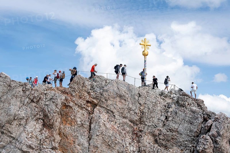 Many tourists at the summit of the Zugspitze with golden summit cross, overtourism, Wetterstein range, Bavaria, Germany