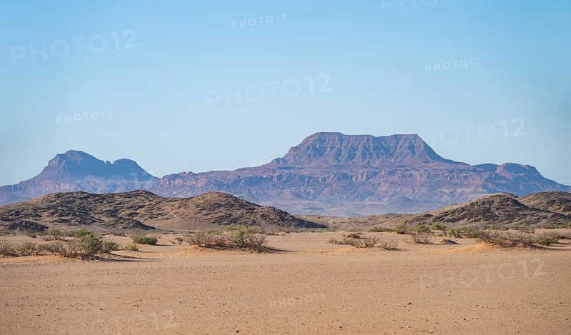Mountains in a barren desert landscape, silhouettes against the light, Damaraland, Kunene, Namibia