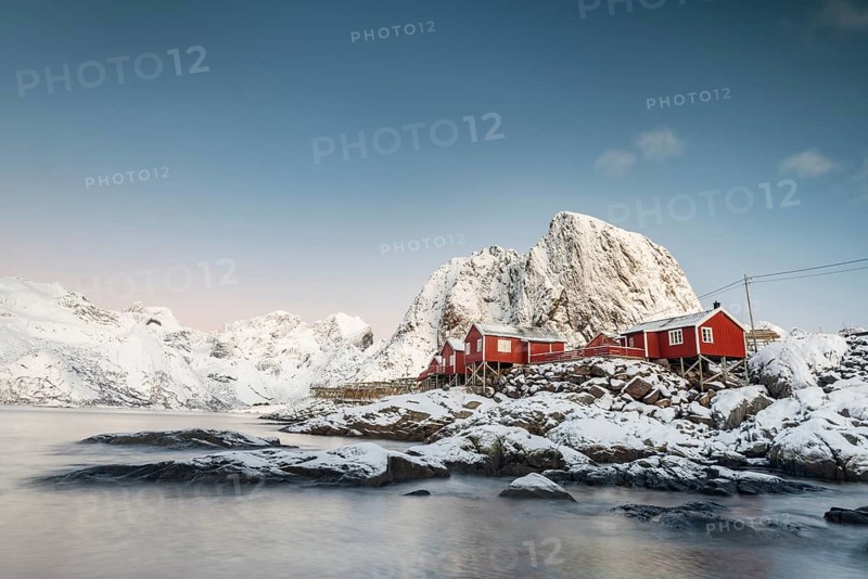 Town and fisherman's cabins or Rorbus in front of snowy mountains, winter, Hamnøy, Moskenesøy, Lofoten, Norway