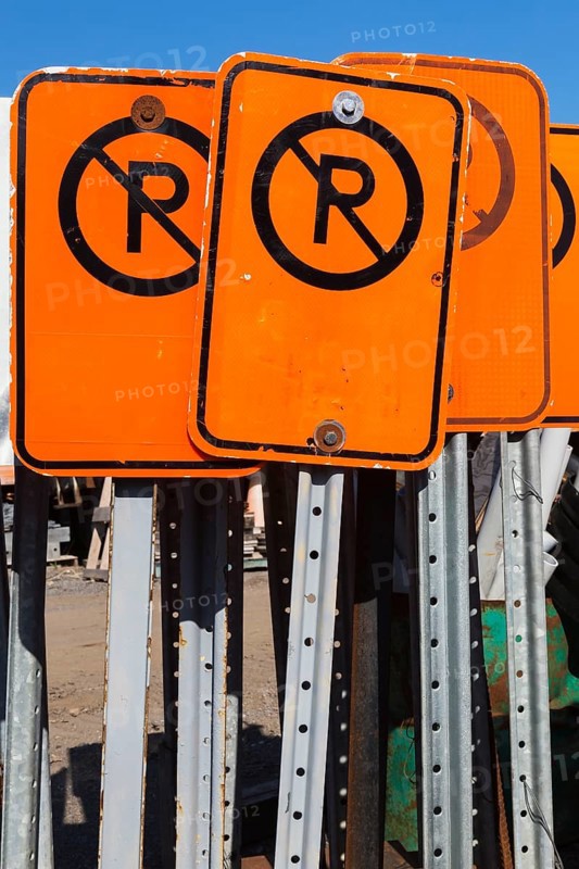 Close-up of fluorescent orange and black No Parking mobile street signs, Quebec, Canada