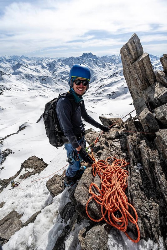 Mountaineer belaying with rope, climbing up a steep snow slope, belaying with rope, ascent to the summit of Piz Grialetsch in winter, view of mountain panorama with Piz Vadret with snow, Grisons Haute Route, Albula Alps, Rhaetian Alps, Grisons, Switzerland