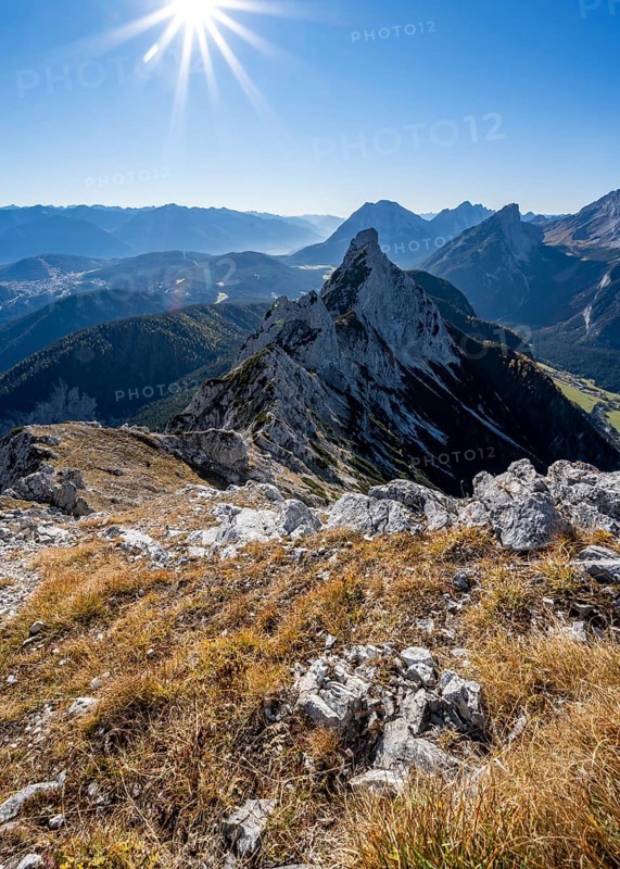 View at the summit of the Große Arnspitze, mountain panorama with Leutasch valley and Arnplattenspitze, sun star, autumnal mountain landscape, near Scharnitz, Bavaria, Germany