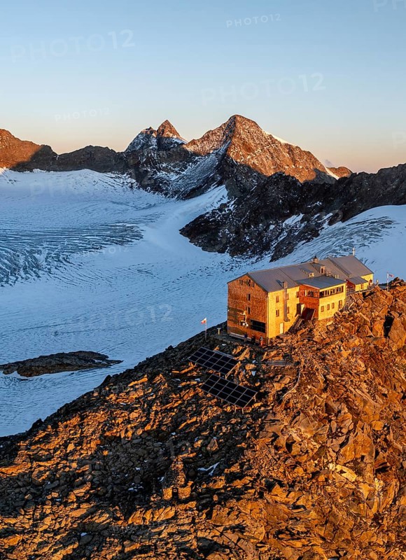 Atmospheric sunrise in a picturesque mountain landscape, alpenglow, aerial view, mountain hut Becherhaus at the summit Becher and glacier Übeltalferner, Stubai Alps, South Tyrol, Italy