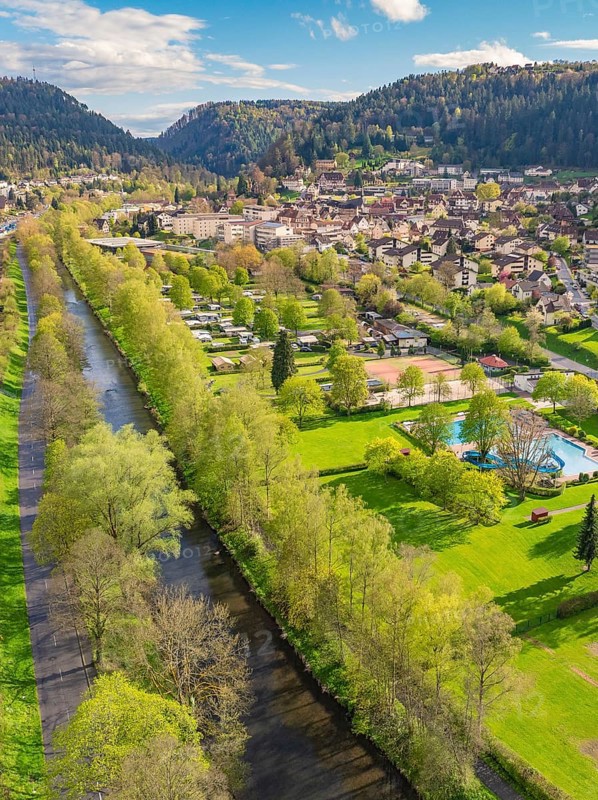 River runs through green landscape near town in mountainous surroundings, Bad Liebenzell, district of Calw, Black Forest, Germany