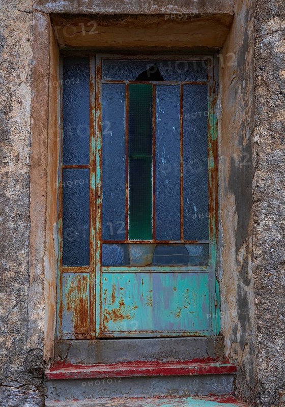 Weathered glass entrance door, mountain village of Lakkoi, Crete, Greece