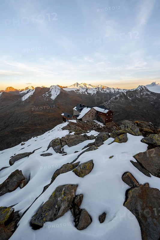 Snow-covered mountain landscape, mountain hut Ramolhaus in autumn with snow, at sunset, view of Gurgler Ferner with summit Hochwilde and Falschungsspitze, Ötztal Alps, Tyrol, Austria