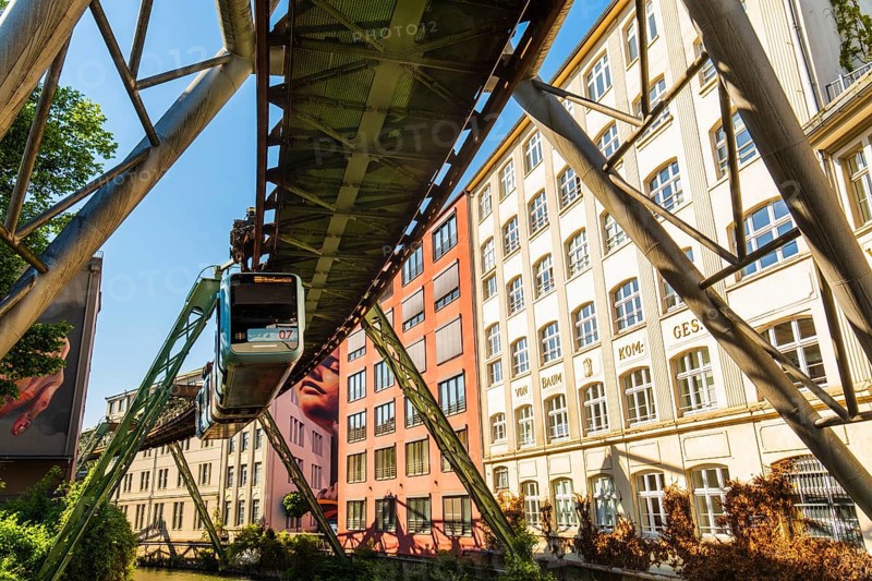 A suspension railway runs between old industrial buildings near the Kluse stop, Wuppertal, Germany